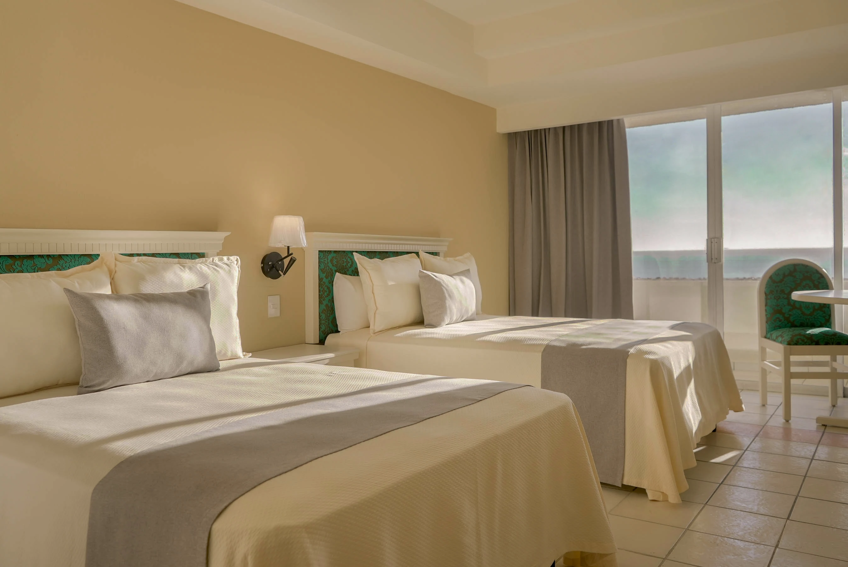 Habitación con vista al mar, dos camas matromoniales, cortinas traslucidas, balcón en Zona Dorada Mazatlan